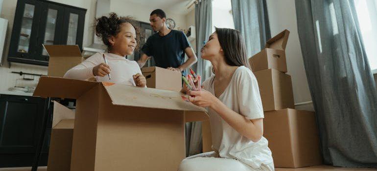 mother and daughter drawing on the moving boxes